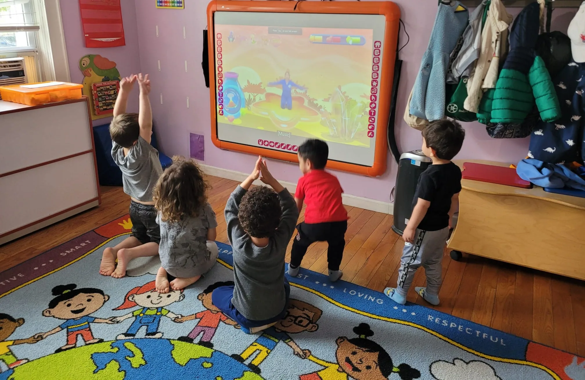 Children moving to a lesson on the classroom smart board