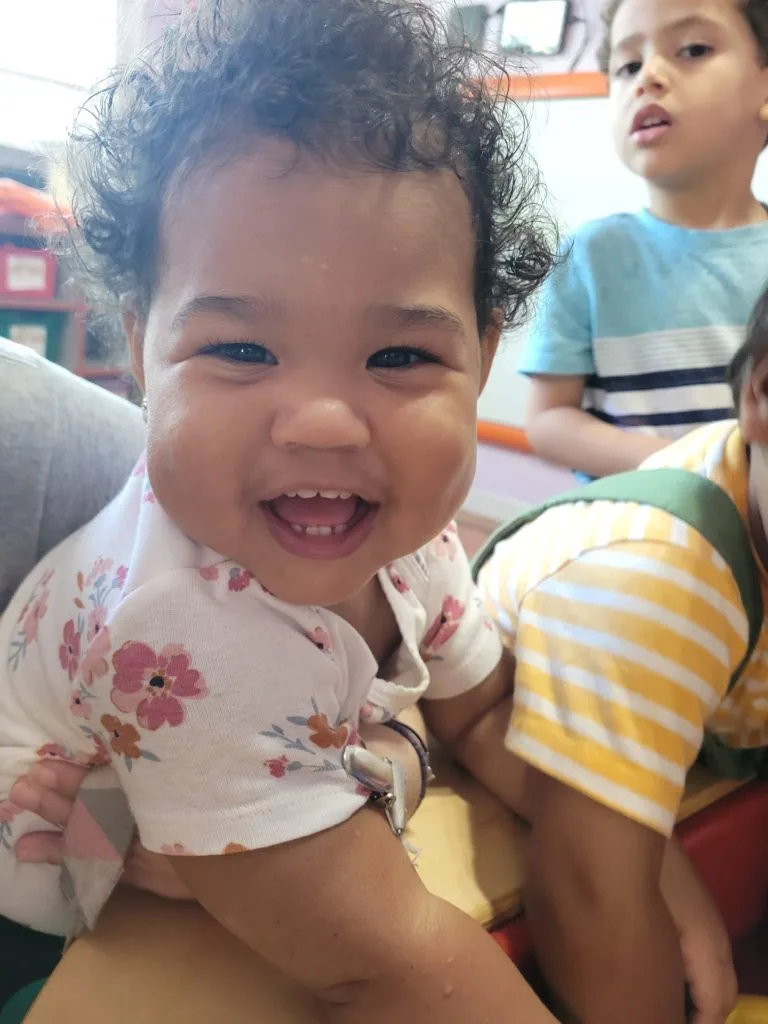 A smiling baby in the infant room at Rainbow Palace