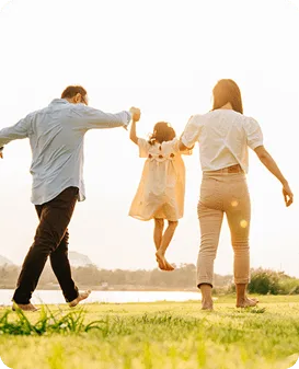Parents walking hand in hand with their young daughter outdoors