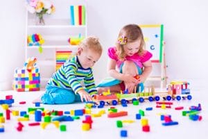 Two children playing with colorful building blocks