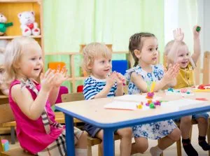 Preschoolers raising their hands in class