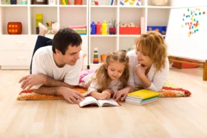 Parents reading with their young daughter on the floor