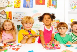 Preschoolers showing their art projects in a bright classroom